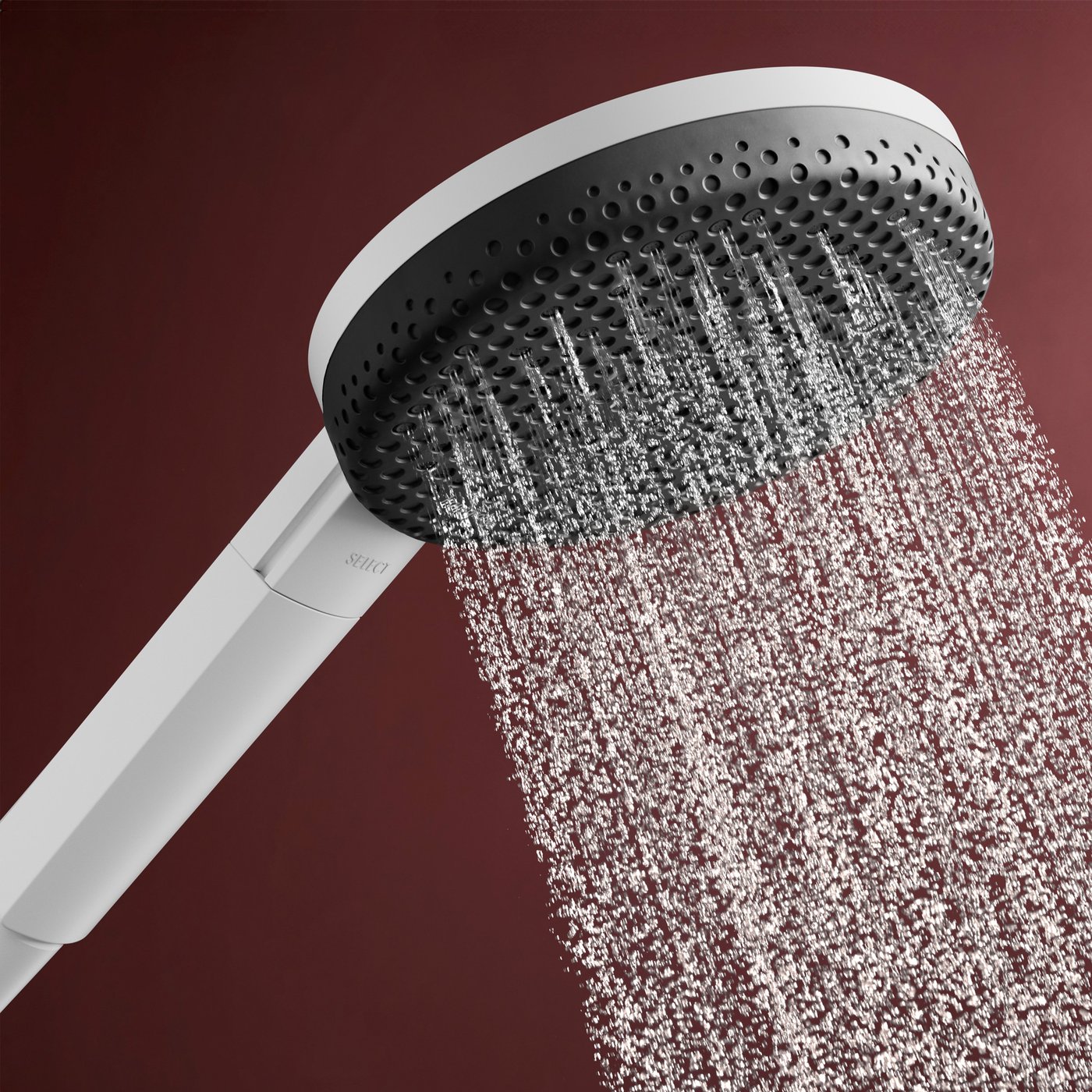 Water jet flow from the matt white shower head of the Hansgrohe Raindance Alive shower system, supplied by Deluxe Bathrooms.