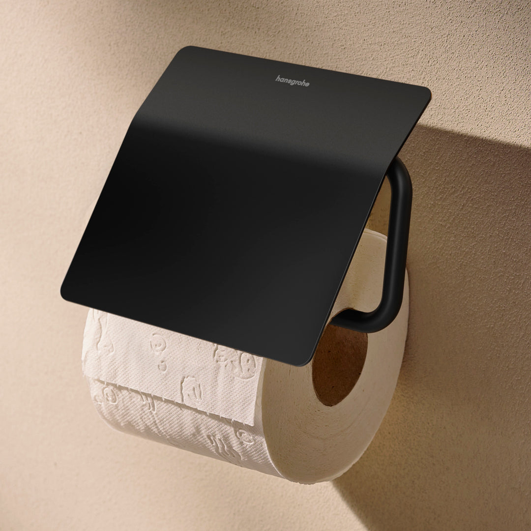 Photo of the Hansgrohe AddStoris S Toilet Roll Holder with Cover in matt black finish, with a toilet roll in place.