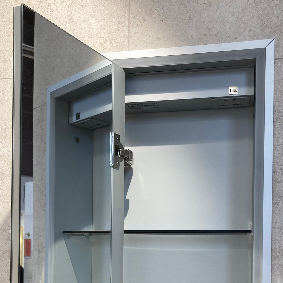 Hib Vanquish 30 Wall Mounted Recessed Cabinet with door open showing internal mirror, shelving and integrated charging sockets.