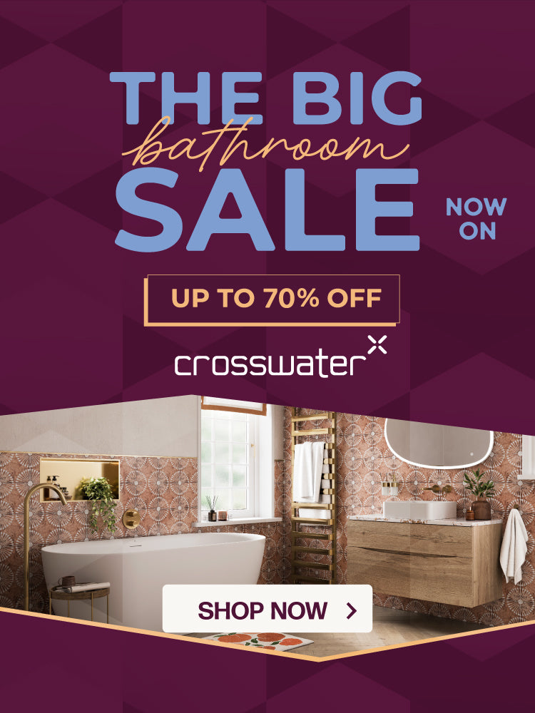 Promotional advertisement for Crosswater featuring large text reading 'THE BIG bathroom SALE NOW ON' and 'UP TO 70% OFF' on a dark purple geometric background, with a bathroom interior photo showing a freestanding tub, wood vanity, and patterned tiles, plus a 'SHOP NOW' button.