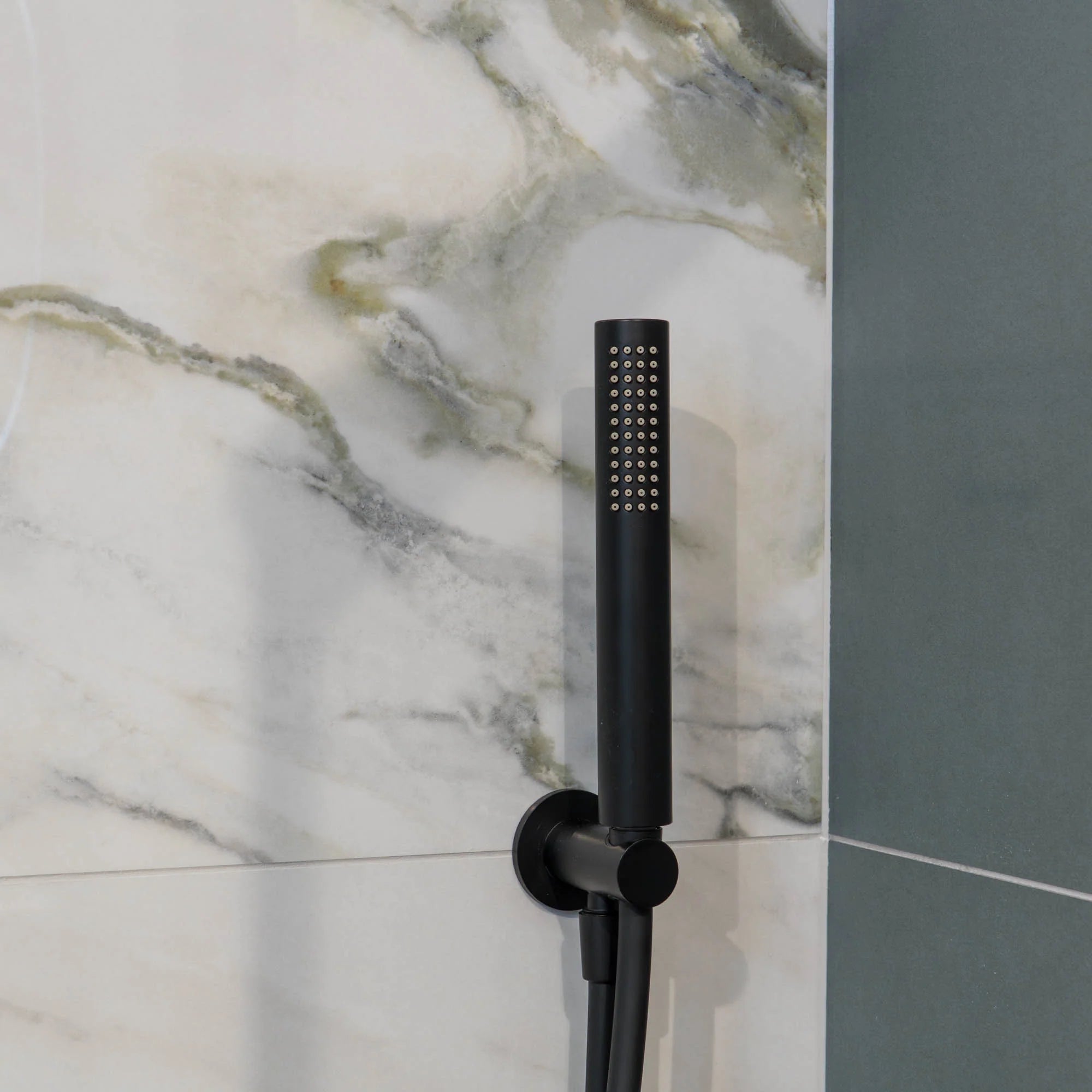 Matt black shower head mounted on a marble wall deluxe bathrooms