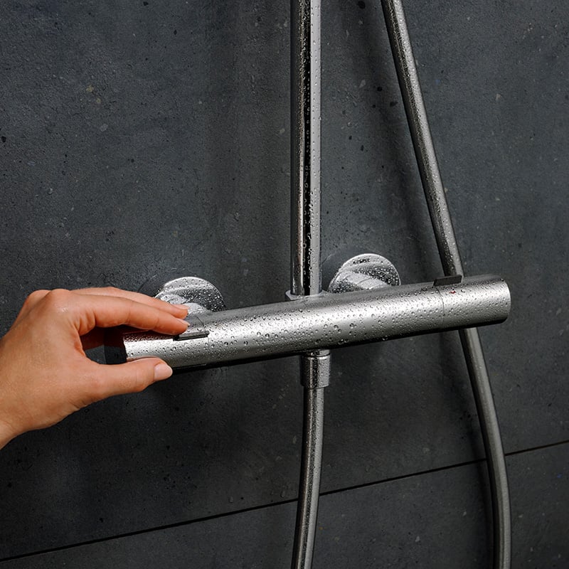 User operating the thermostat of the Hansgrohe Pulsify S Puro Shower Set, in Chrome, supplied by Deluxe Bathrooms.