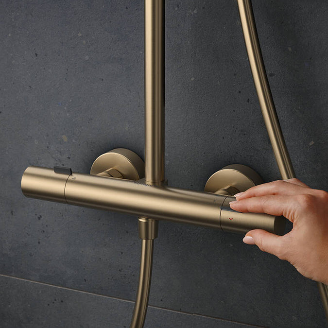 Adjusting the water temperature on the Thermostat of the Hansgrohe Pulsify S Puro Shower Set, in Brushed Bronze, supplied by Deluxe Bathrooms.