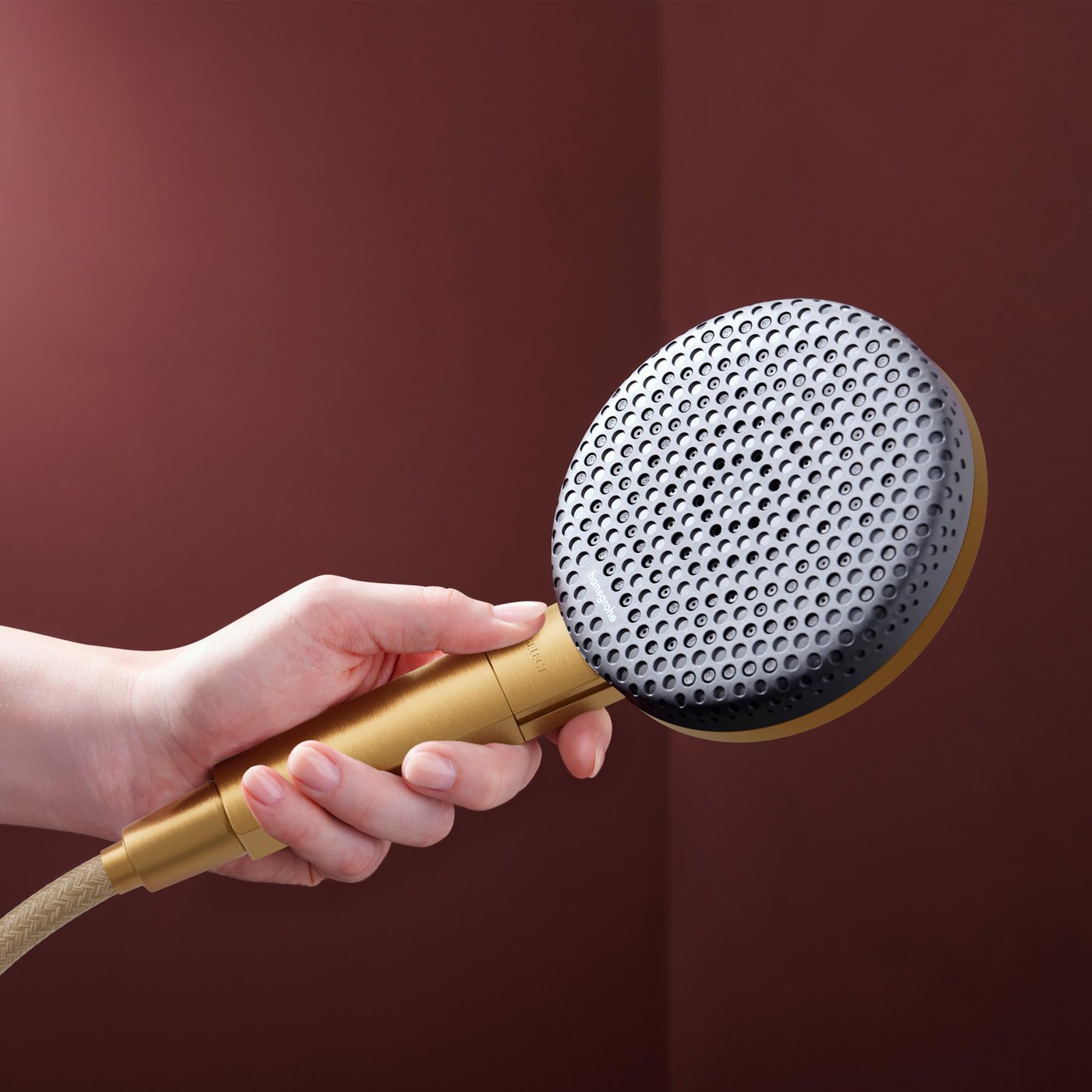 Close up view of the brushed bronze shower head from the Hansgrohe Raindance Alive shower system, supplied by Deluxe Bathrooms.

