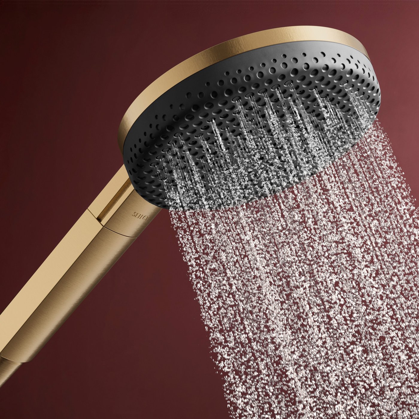 Water jet flow from the brushed bronze shower head of the Hansgrohe Raindance Alive shower system, supplied by Deluxe Bathrooms.