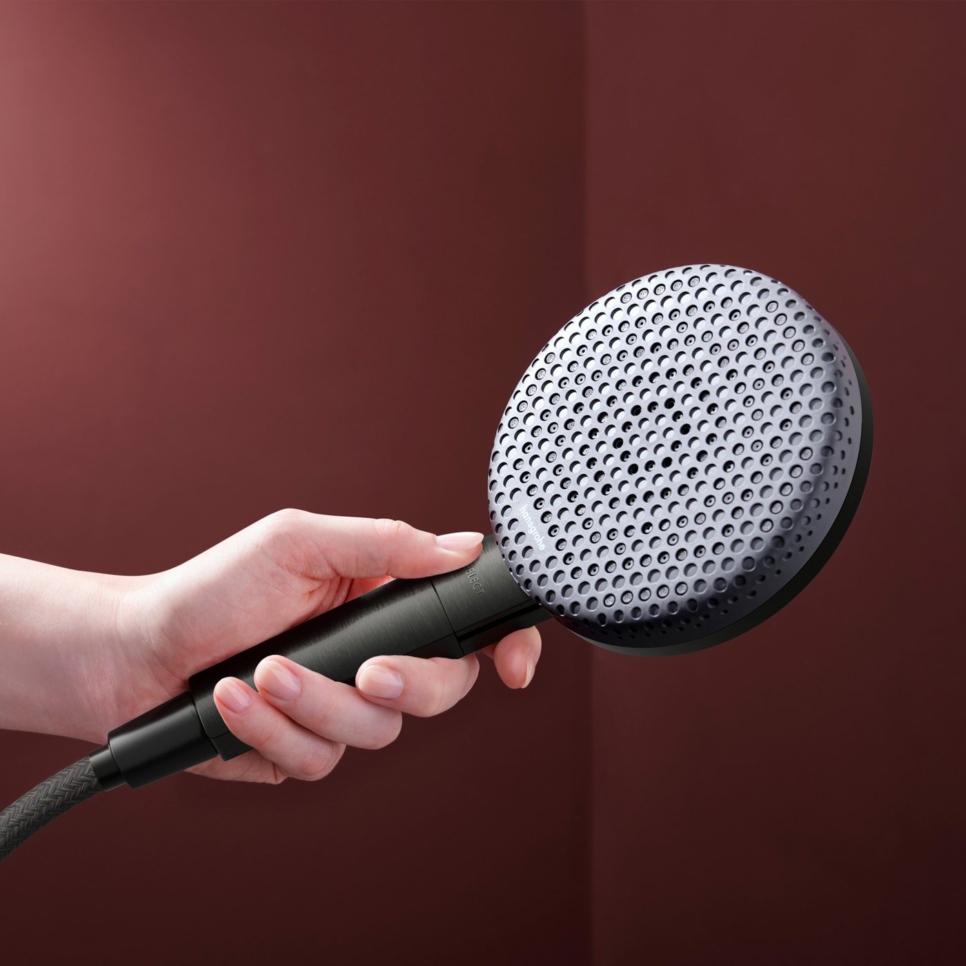 Close up view of the brushed black chrome shower head from the Hansgrohe Raindance Alive shower system, supplied by Deluxe Bathrooms.
