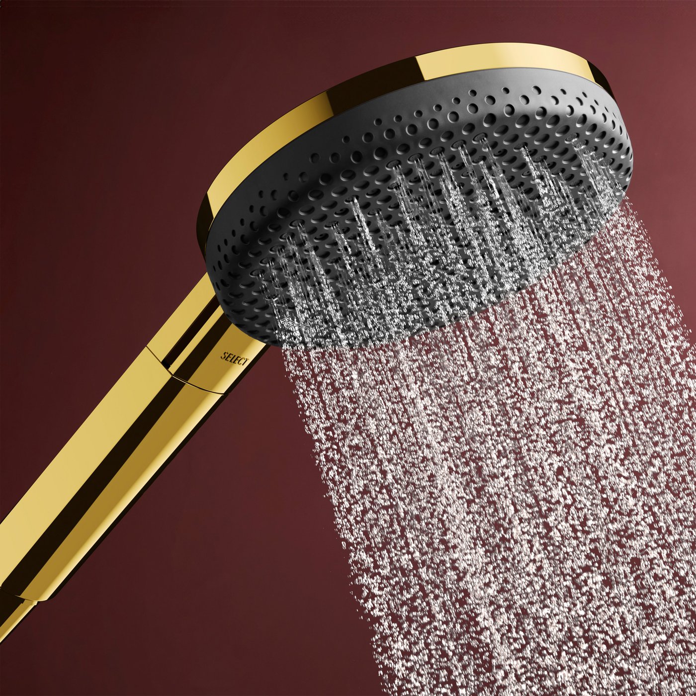 Water jet flow from the polished gold shower head of the Hansgrohe Raindance Alive shower system, supplied by Deluxe Bathrooms.