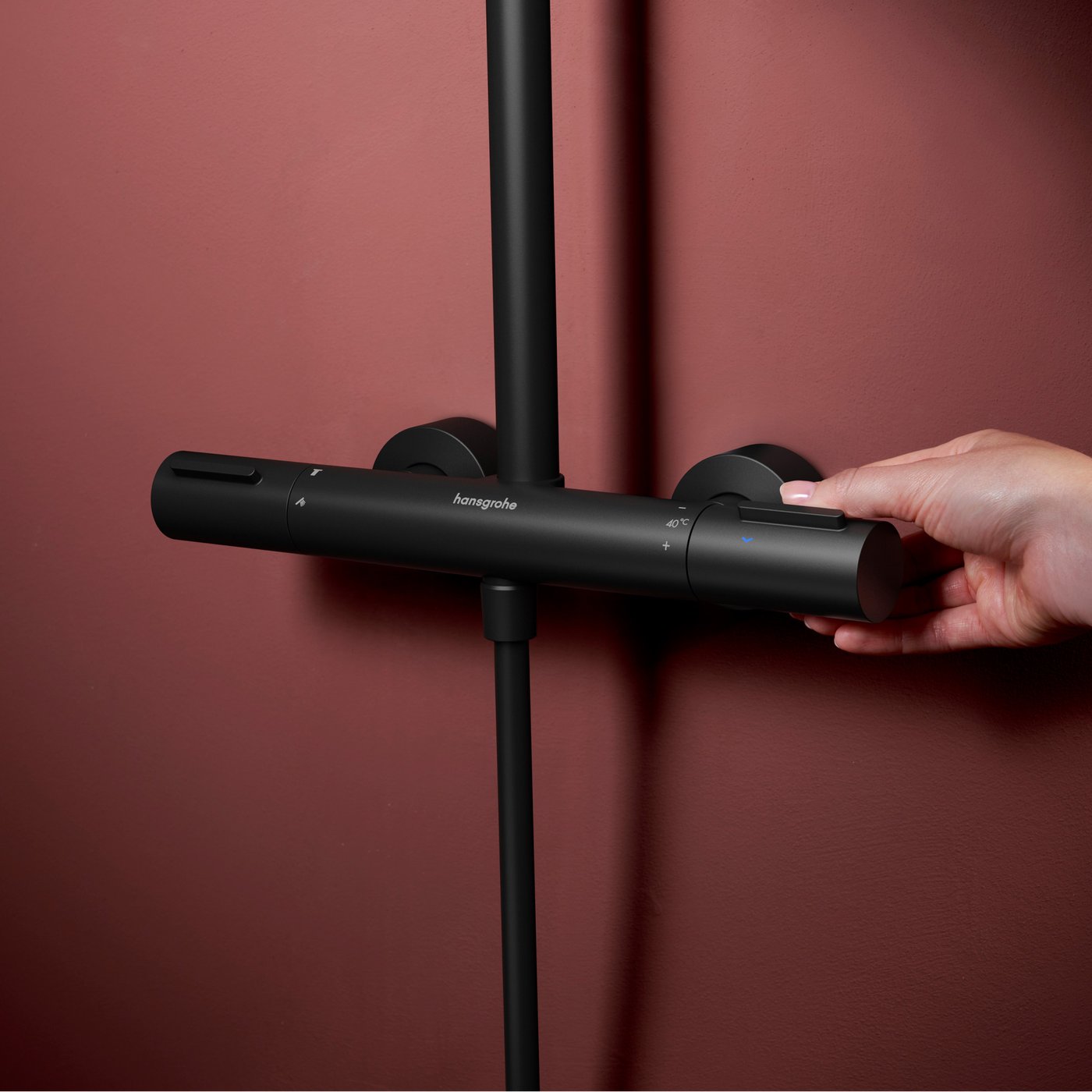 Person adjusting the matt black thermostat on the Hansgrohe Raindance Alive shower system, supplied by Deluxe Bathrooms.
