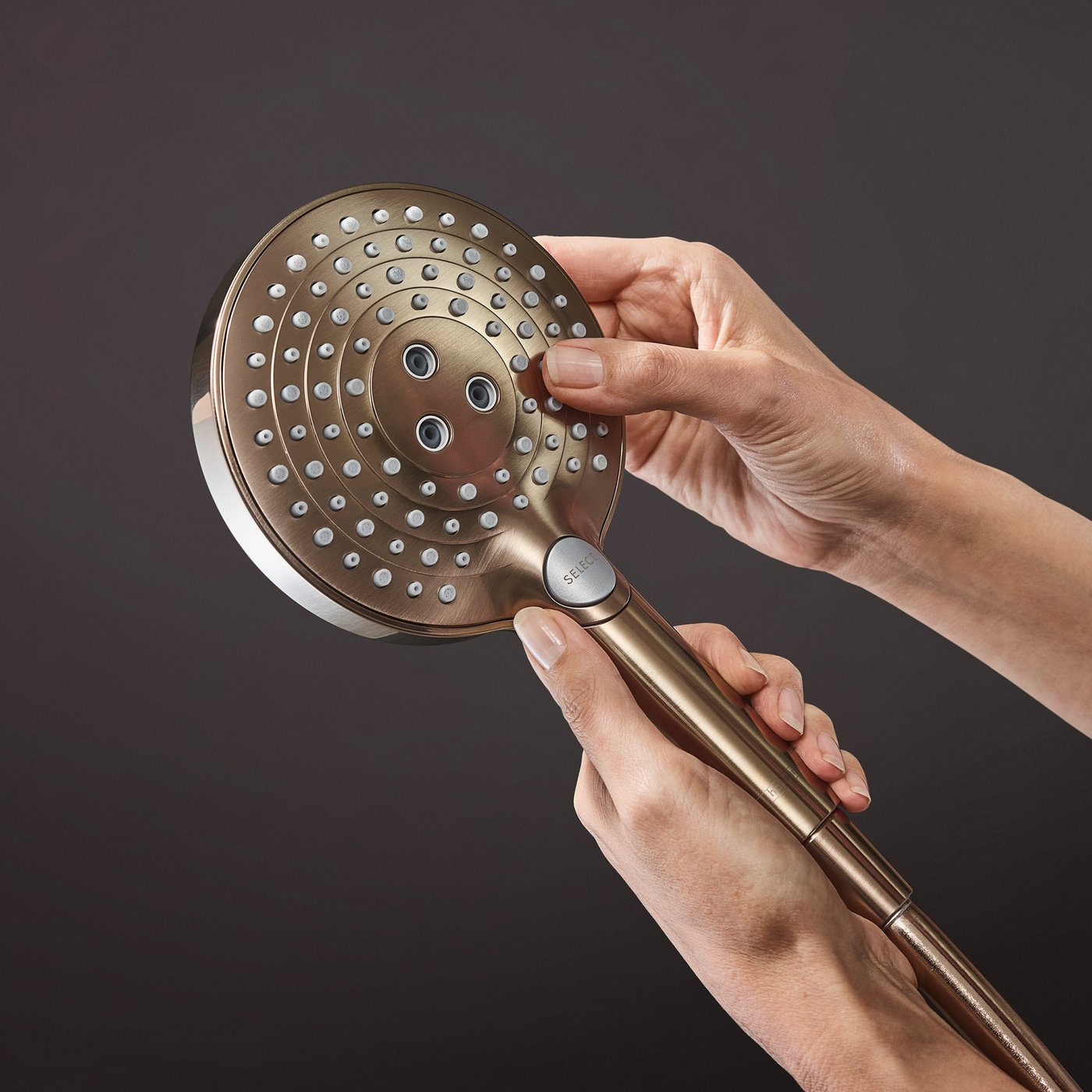 Handset shower head nozzles view of the Hansgrohe Raindance Select 1-Jet Shower system in brushed bronze.