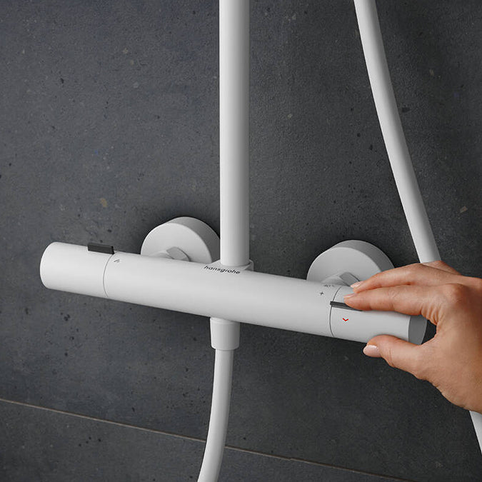 Adjusting the water temperature on the thermostat of the Hansgrohe Pulsify S Puro Shower Set in matt white, supplied by Deluxe Bathrooms.