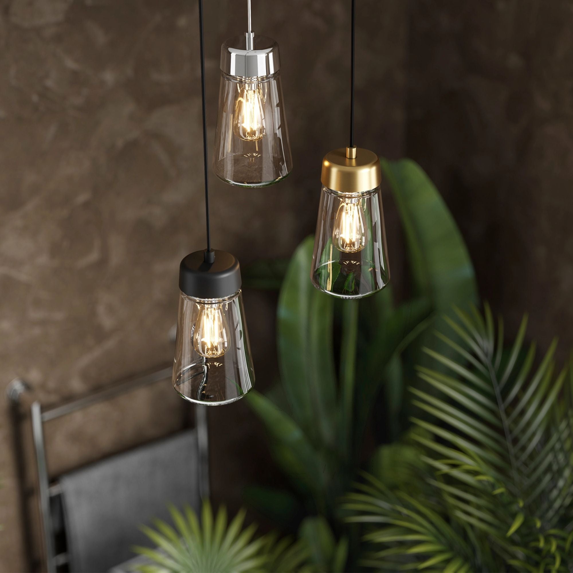 Hib summit three pendant lights hanging against a dark wall with green foliage.