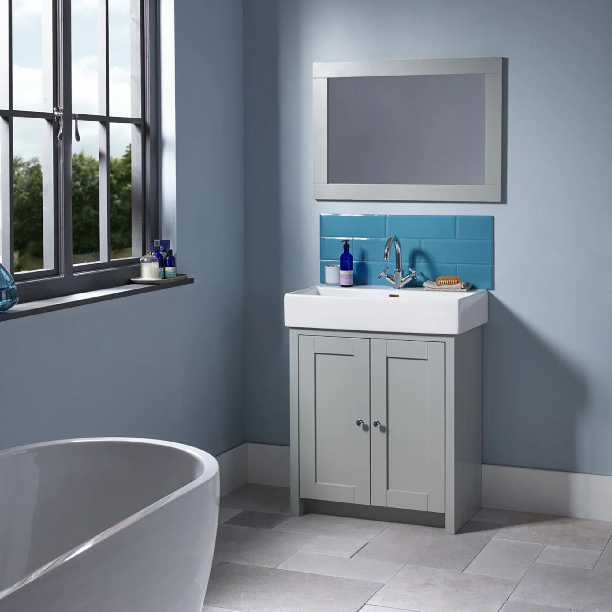 Tavistock lansdown bathroom with a freestanding bathtub, vanity unit, and mirror deluxe bathroom
